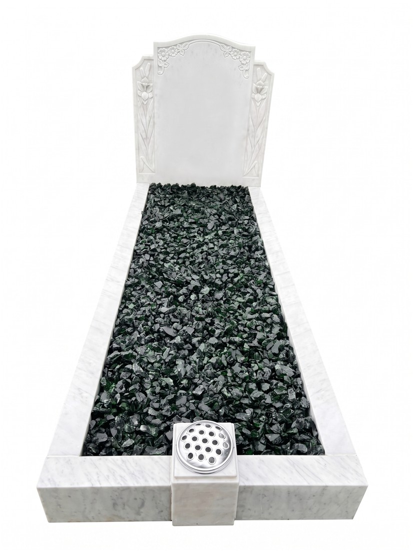 A pale decorative headstone with contrasting dark chippings.