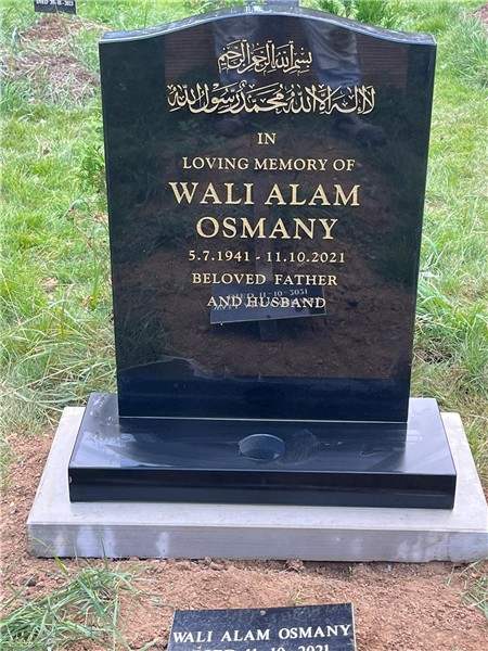 Dark headstone with gold lettering