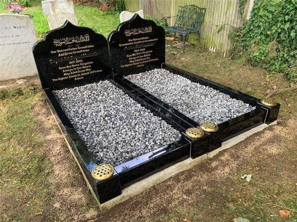 Two dark headstones with adjoining surrounds