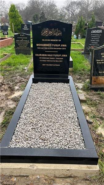 Dark headstone with a chipping-filled surround