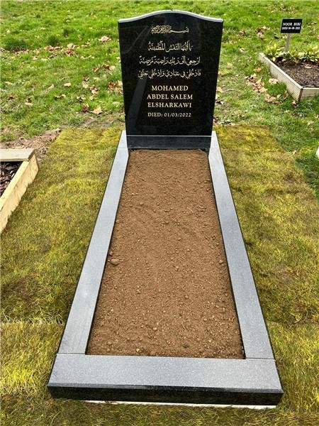 Dark headstone with a pale kerbed surround
