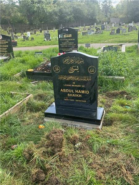 Dark shaped headstone in a cemetery