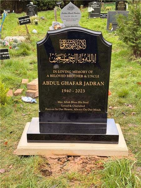 Dark headstone with ornamental gold details