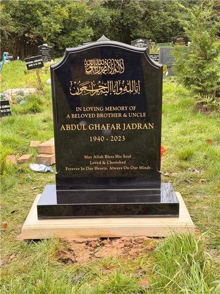 Dark headstone with ornamental gold details