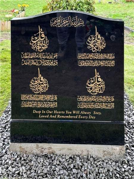 Dark headstone with decorative inscription