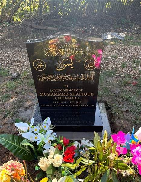 Dark headstone with flowers