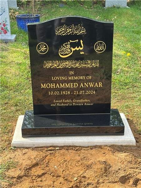 Dark headstone with gold lettering