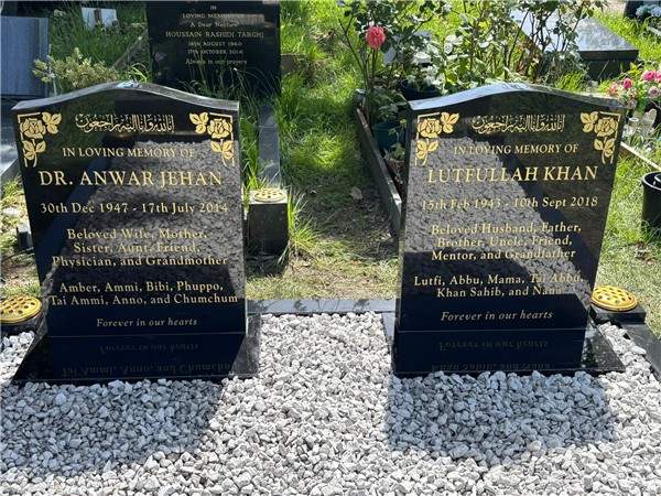 Paired dark headstones with gold inscriptions